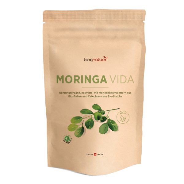 Moringa Vida_Nachfüllbeutel_Front_v1.0 Ein beigefarbener Beutel mit der Aufschrift „Moringa Vida Bio“ zeigt ein grünes Blatt, Bio- und Vegan-Symbole sowie einen Text über Bio-Moringa-Blattpulver – ideal für alle, die Moringa-Kapseln kaufen möchten. Auf der Unterseite steht „Swiss Made“.