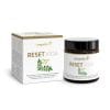 Eine weiße Schachtel und ein dunkles Glasgefäß mit der Aufschrift „Reset Vida“ zeigen Grafiken mit grünen Blättern und Blumen, Produktdetails und Markenzeichen sind in goldener und grüner Schrift dargestellt.