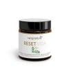 Ein braunes Glas mit schwarzem Deckel und der Aufschrift „Reset Vida“. Das Etikett zeigt grüne Blätter und weist darauf hin, dass es sich um ein Nahrungsergänzungsmittel mit japanischen Rosinen, L-Carnosin und Vitamin B12 handelt.